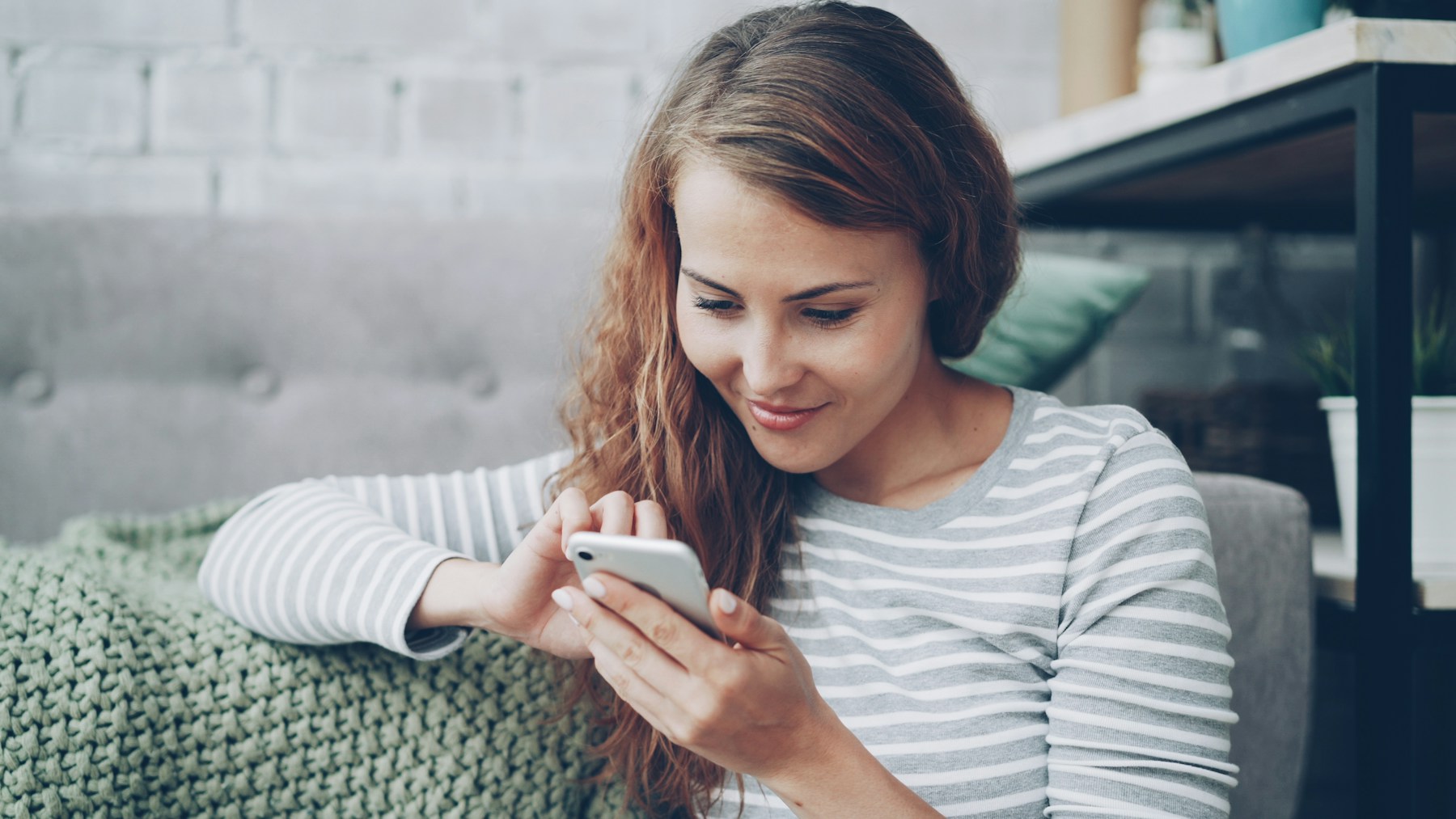 A woman checking her phone at home